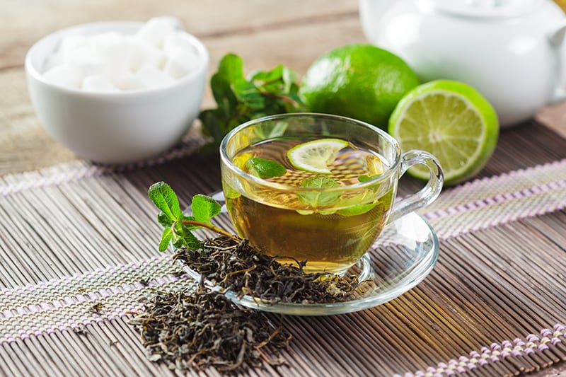 cup of tea with mint on wooden background