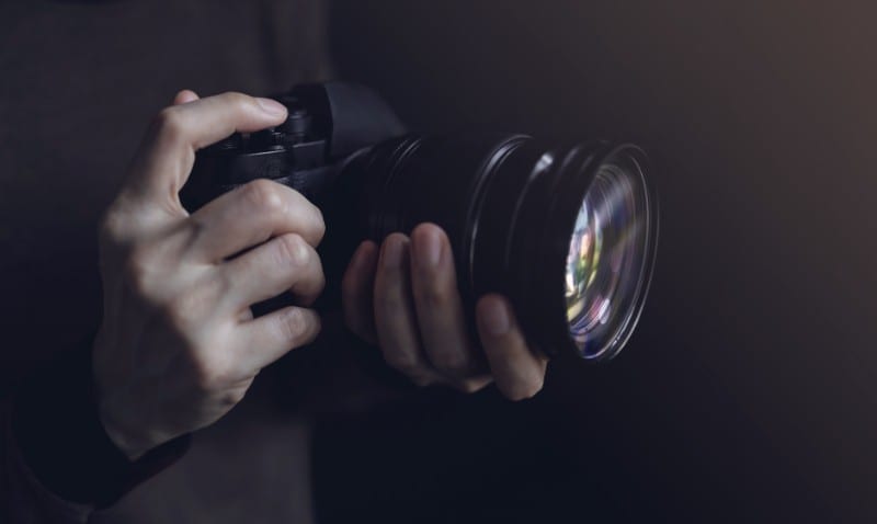 Close up of a camera and hands holding the camera