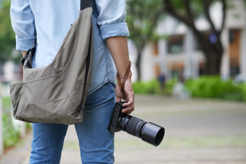 Photographer standing with a bag and camera